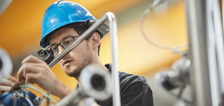 Technician in a hard hat working on equipment