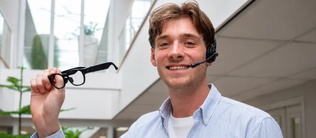 Smiling VR Expert specialist with a headset holding AI glasses